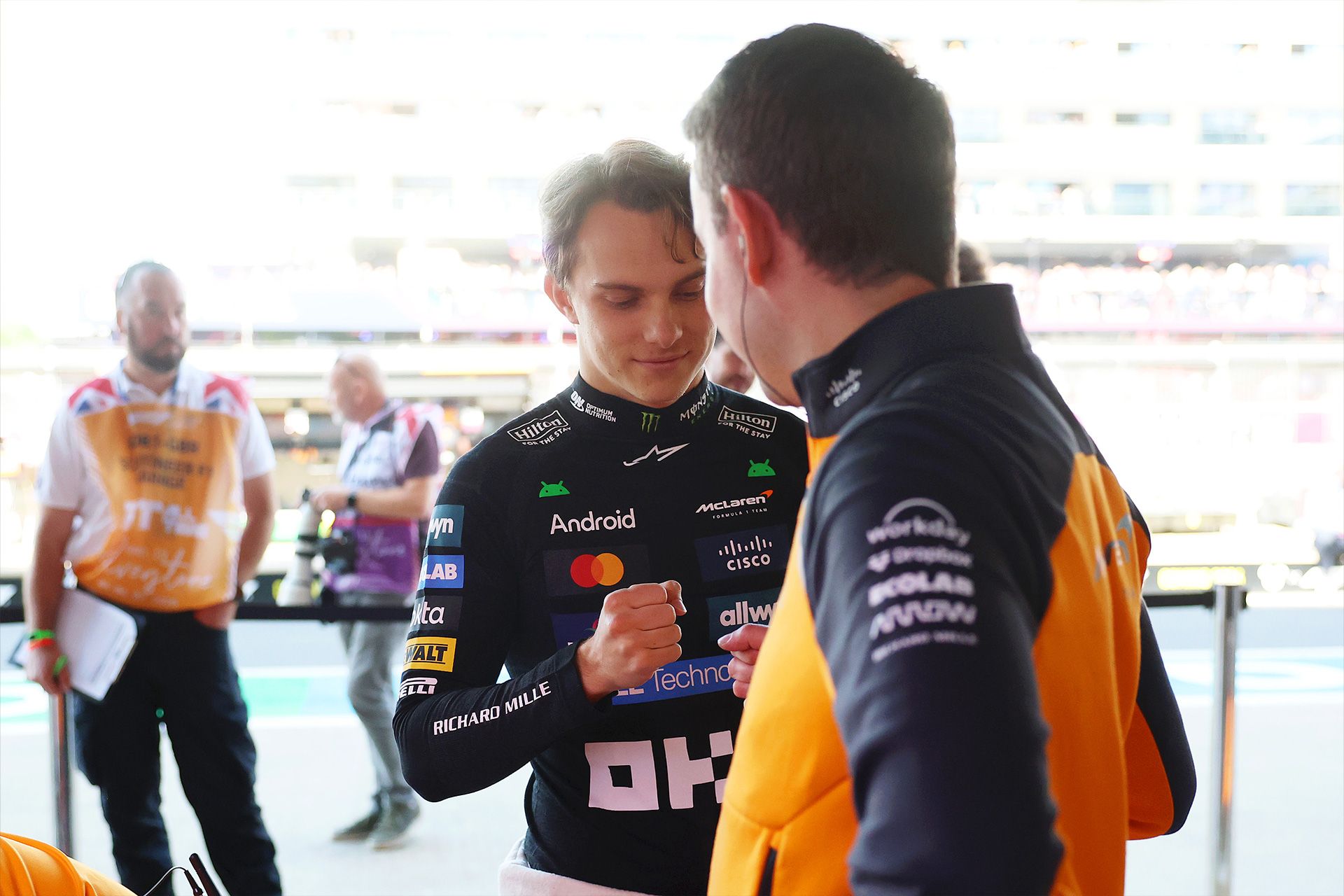 Oscar in the garage fist bumping a team member