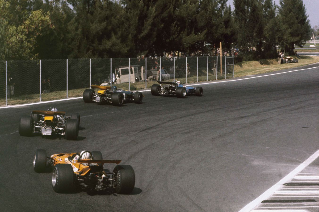 Denny Hulme in the McLaren M7A Ford, chasing down Jackie Stewart, Jacky Ickx, and Jack Brabham